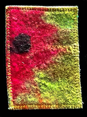 Artist trading card featuring red fabric flower on green background