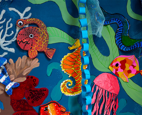 Children's art installation featuring brightly coloured undersea creatures against a painted undersea backdrop.