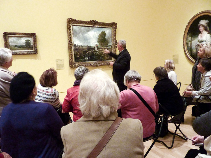Colin Johnson and PAS students at NGV Aug 2012. Colin is discussing a painting to an audience of students.