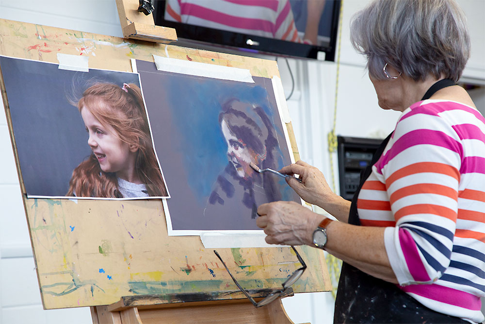 Liz Turner - blocking in lights and dark tones on a pastel portrait painting of a young girl.