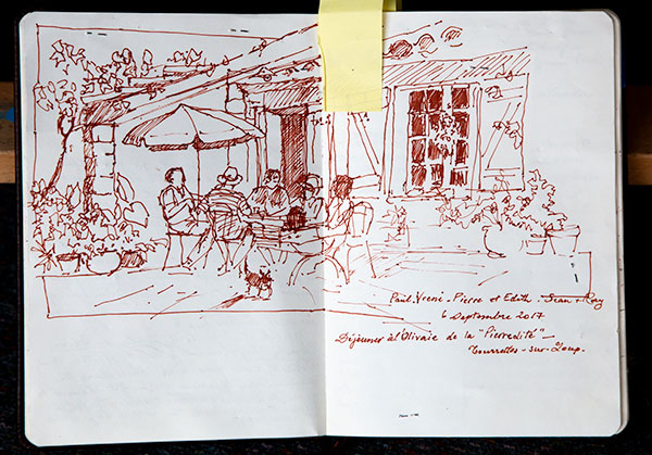 Field sketch of people seated at a table with unbrella, annotations written underneath.